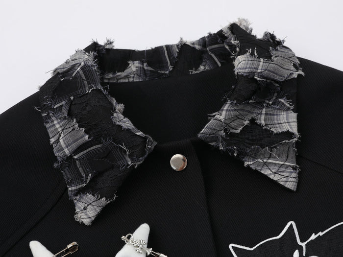 Close-up of patchwork plaid collar on black varsity jacket with frayed edges