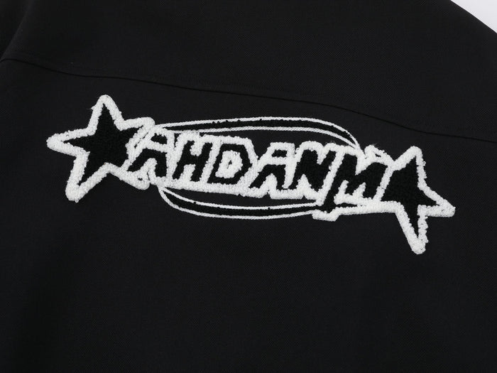 Close-up of star logo embroidery on black jacket back with thick white stitching