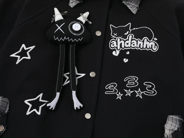 Front close-up of black varsity jacket showing cat graphic, ahdanhm embroidery and star patches