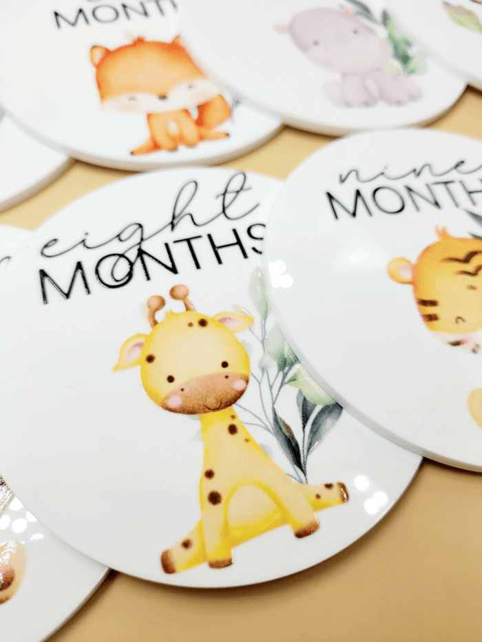 Personalised Baby Milestone Disc Set featuring cute animal designs for monthly growth tracking, including "eight months" disc.