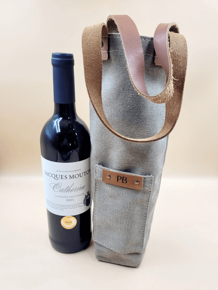 Personalised canvas and leather wine carrier with initials, featuring a bottle of wine, showcasing elegance and durability.