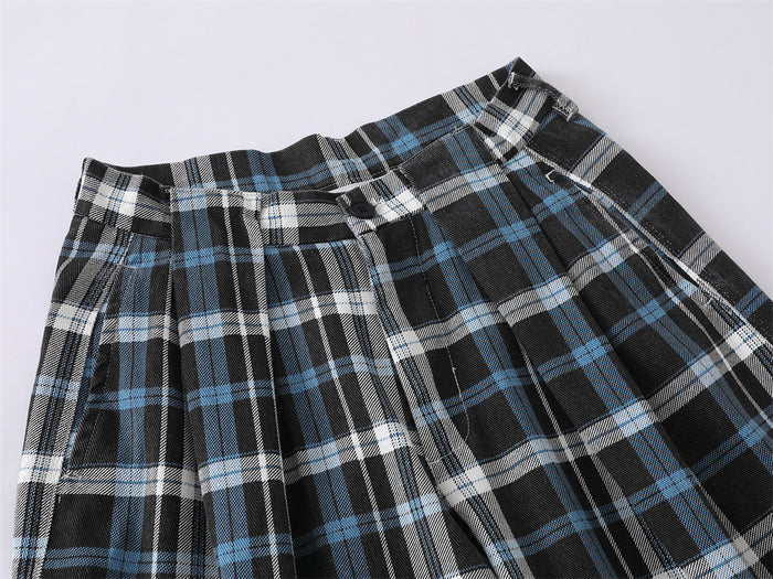 Close-up of plaid trouser waistband with button closure and pleats