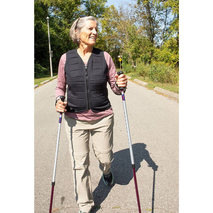 Adult female wearing the Power WearHouse weighted vest while hiking, demonstrating outdoor fitness and bone health use