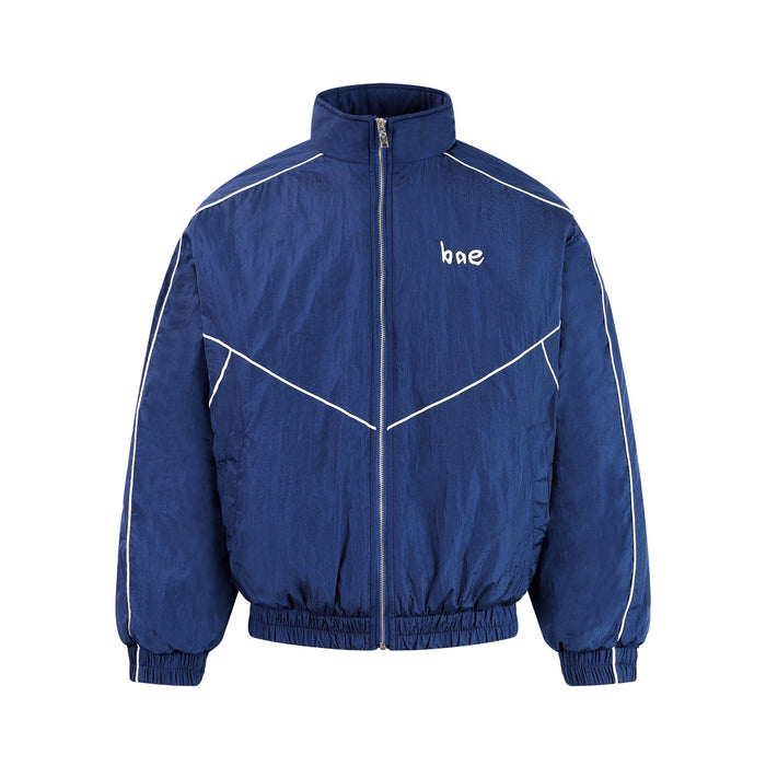 Navy blue crinkle nylon zip-up track jacket with white reflective contrast piping and small chest logo, front view