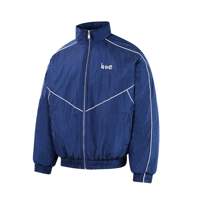 Blue zip-up track jacket with white piping and small bae chest print, front view