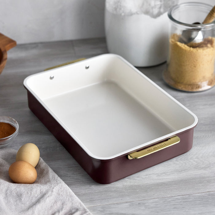 Reserve 13″ x 9″ rectangular pan in Bordeaux, made of aluminized steel with gold-tone handles and a white nonstick interior.