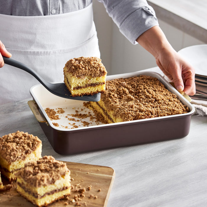A slice of crumb cake being lifted with a spatula from a Bordeaux Reserve Bakeware 13″ x 9″ rectangular pan.
