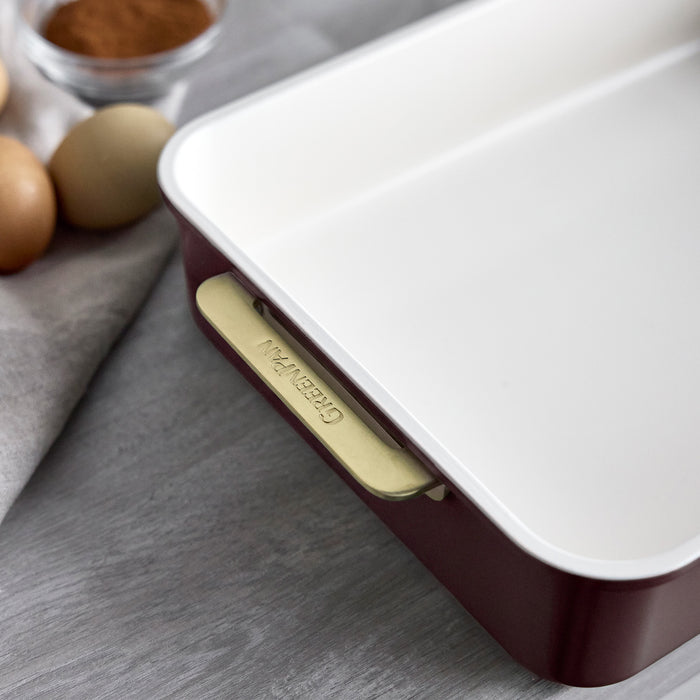 13″ x 9″ rectangular aluminized steel baking pan in Bordeaux with a white interior and gold-toned handles.