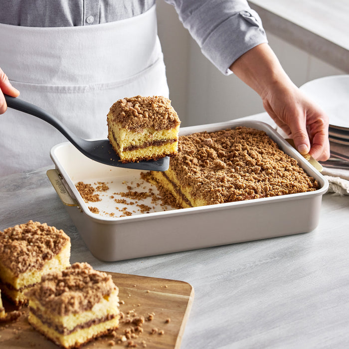 A slice of coffee cake being lifted with a spatula from a latte Reserve Bakeware 13″ x 9″ Rectangular Pan.