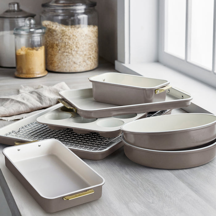 Reserve 8-piece latte aluminized steel bakeware set with cream interiors and gold-toned handles.