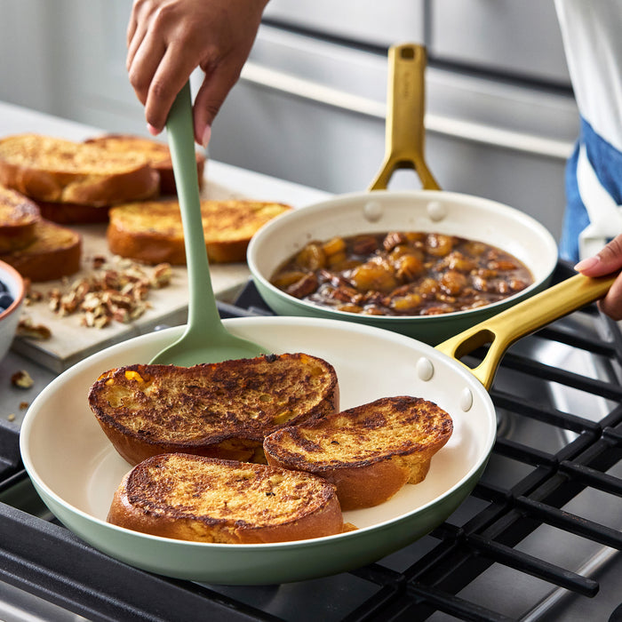 Person cooking French toast in a green pan on a stove