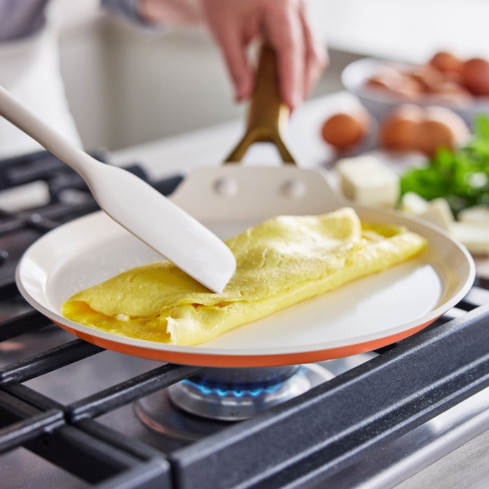 Person cooking an omelette on a stove with a spatula