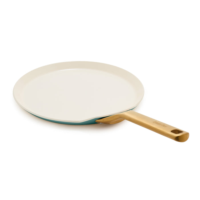 Crepe pan with a gold handle on a white background