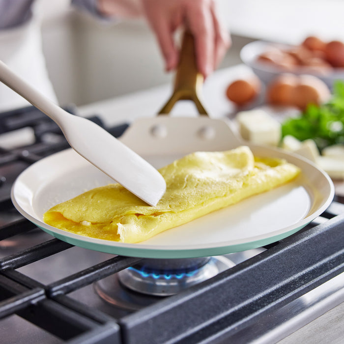 Omelette being cooked on a stove with a spatula