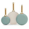Three green frying pans with gold handles on a white background
