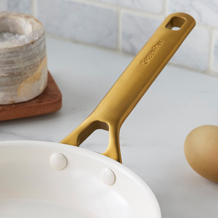 Light blue frypan with a gold handle on a kitchen counter