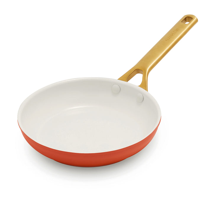 Dark orange frying pan and gold handle on a white background