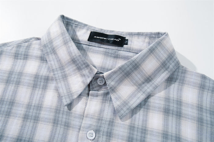 Close-up of the shirt collar and top buttons in light gray plaid