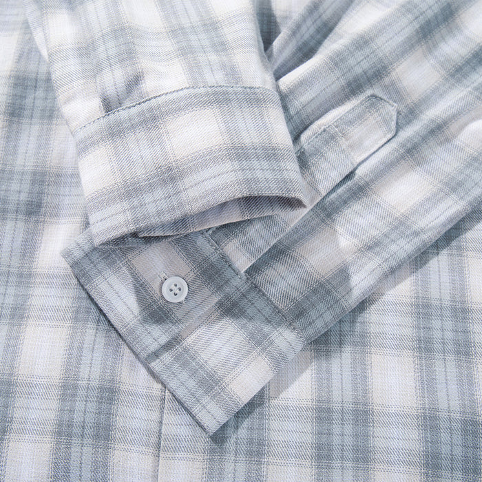 Close-up of cuff and sleeve placket on a light gray plaid shirt