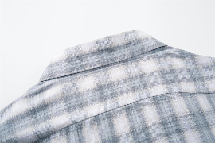 Close-up of the back yoke and collar on a light gray plaid shirt