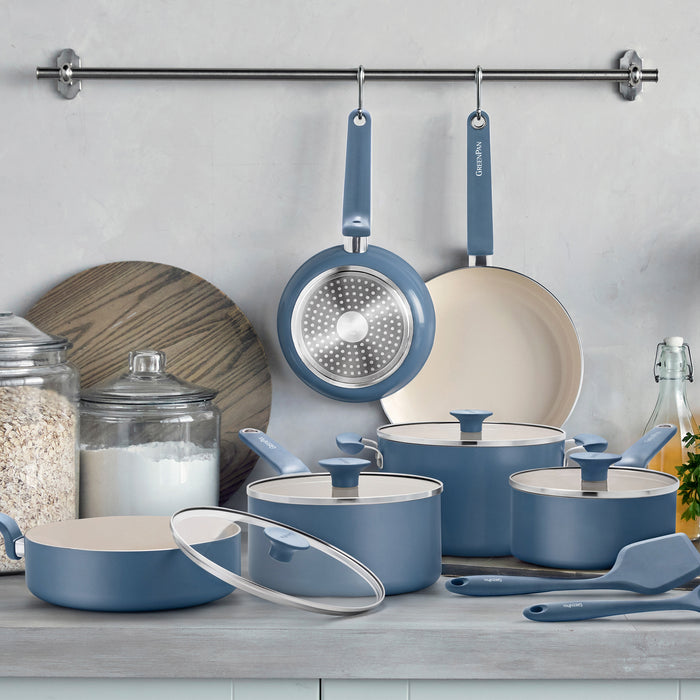 12-piece Dutch blue ceramic cookware set with pots, pans, and lids arranged on a kitchen counter.