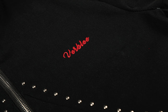Close-up of red embroidered logo on black jacket fabric
