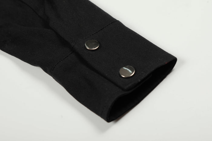 Black jacket sleeve cuff with two silver snap buttons