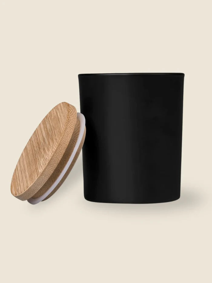 Black cylindrical container with a wooden lid on a beige background