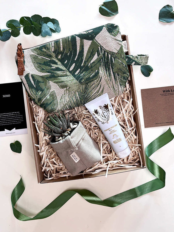 Scented Joy gift set featuring Joy Republic Vanity Bag, Soft Pots with succulent, and Cape Island Clifton Beach Cream in a box.