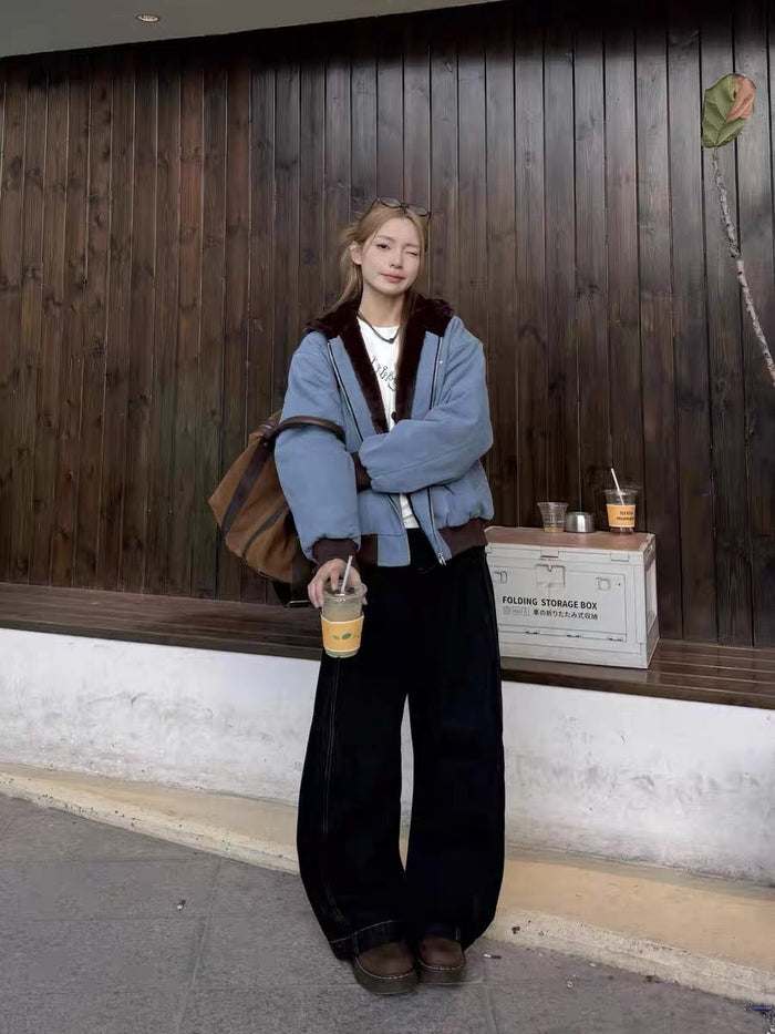 Model wearing light blue fur-lined zip-up hoodie with black pants and tote bag