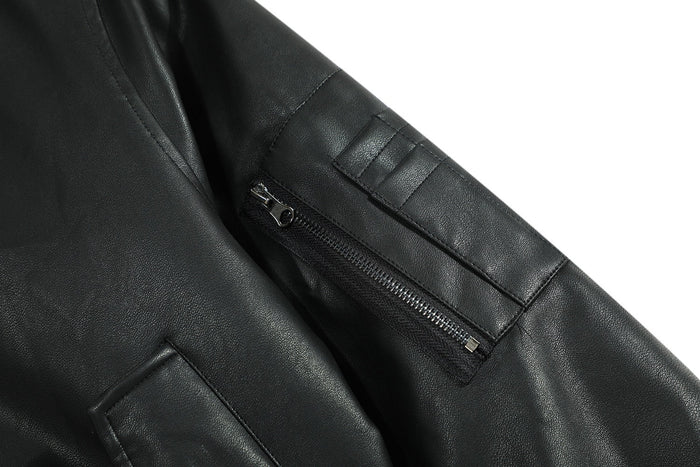 Close-up of the sleeve zip pocket and patch detail on black PU jacket