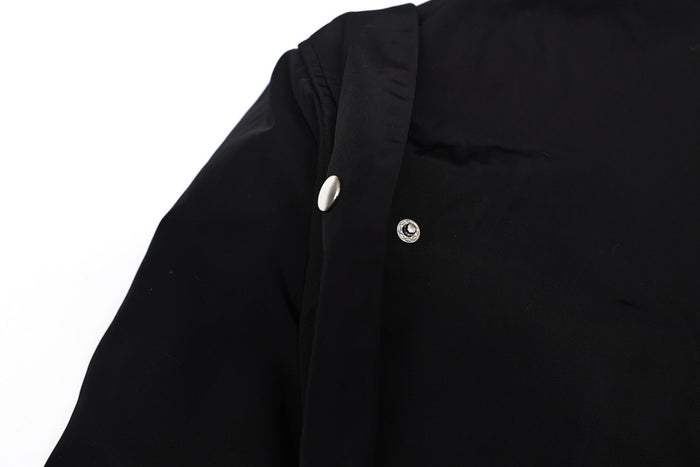 Close-up of black bomber jacket shoulder with snap button detail