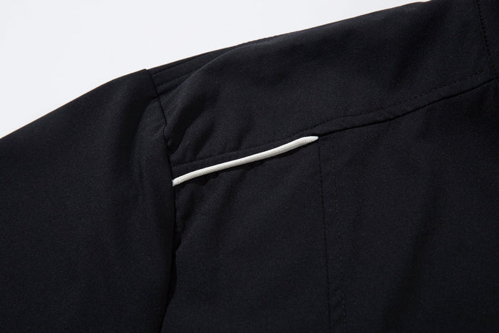 Close-up of black shoulder seam with a white piping detail
