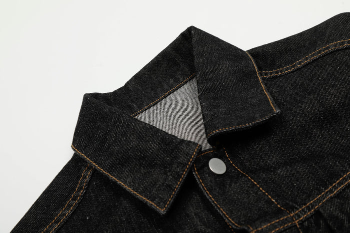 Close-up of the collar on a black denim jacket with tan contrast stitching