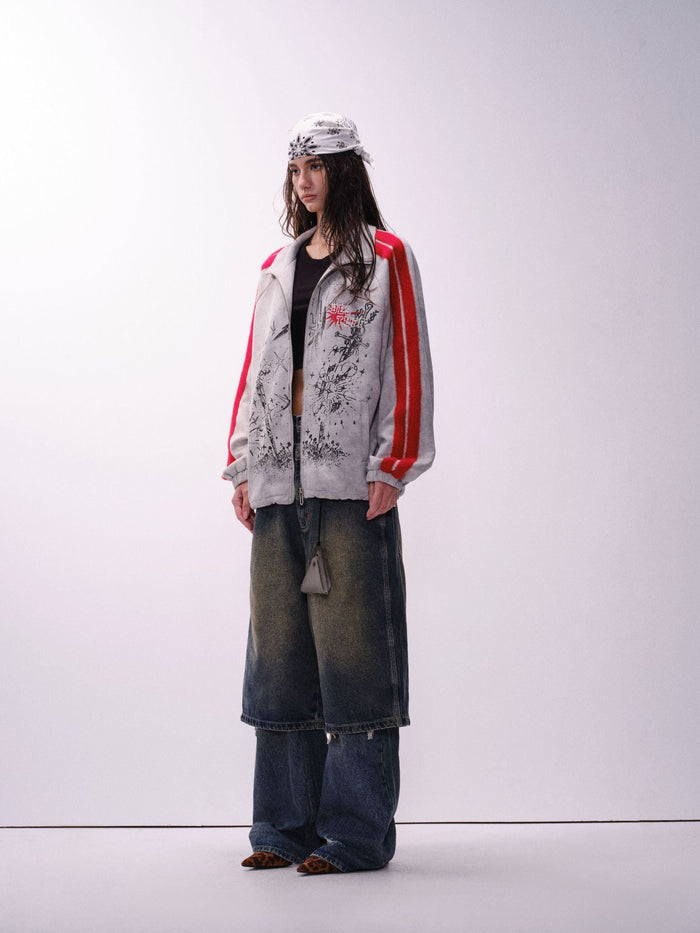 Full-body view of a gray track jacket with red striped sleeves, black graphic print, and wide jeans