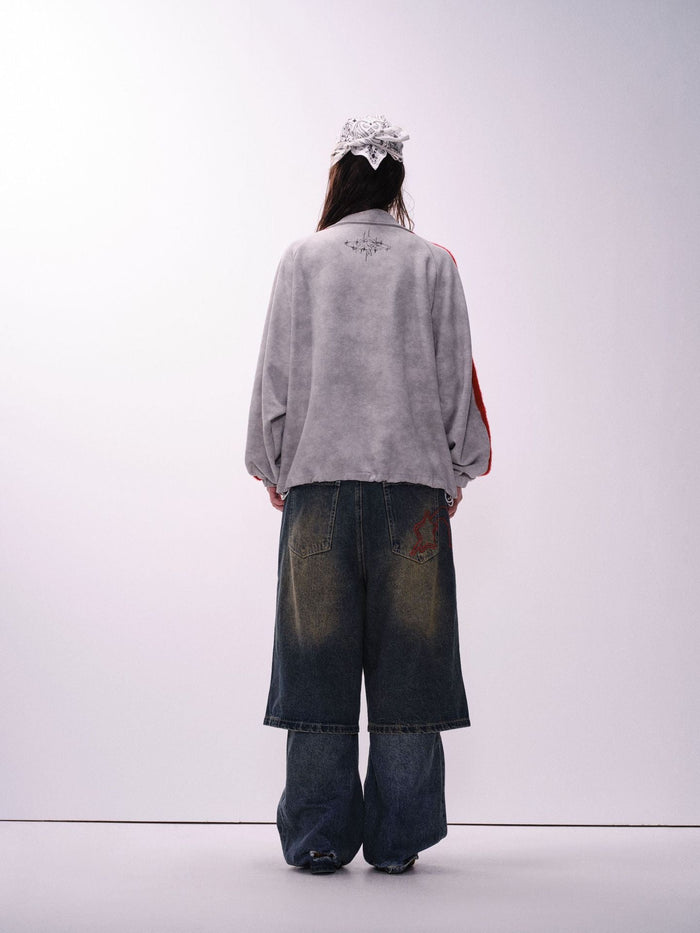 Back view of a gray jacket with red striped sleeves and small black graphic at the upper back