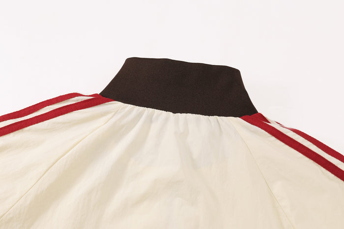Close-up of jacket back collar with cream nylon body and red triple stripes