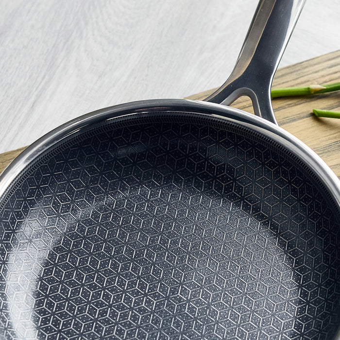 Hybrid ceramic nonstick frypan set on a wooden surface with asparagus spears next to the pans.