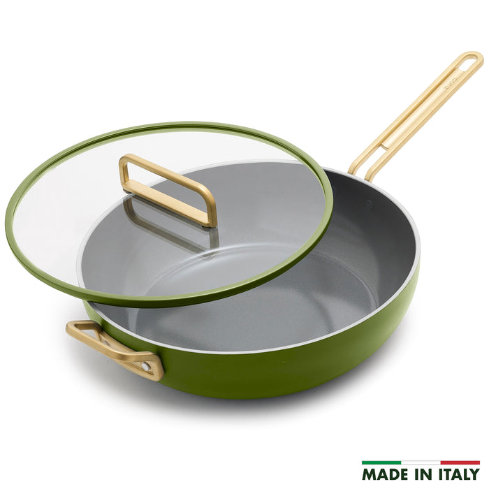 Green saute pan with glass lid on a white background