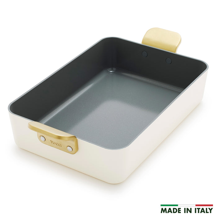 Ceramic lasagna pan in Carrara white with gold handles and cream finish, rectangular shape.