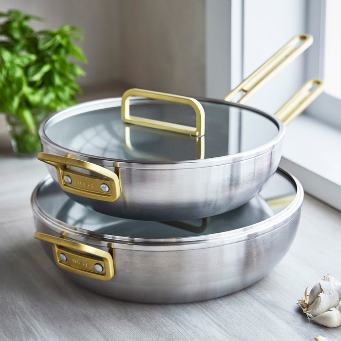 Two stainless steel ceramic nonstick pans stacked beside fresh basil and garlic, set of two.