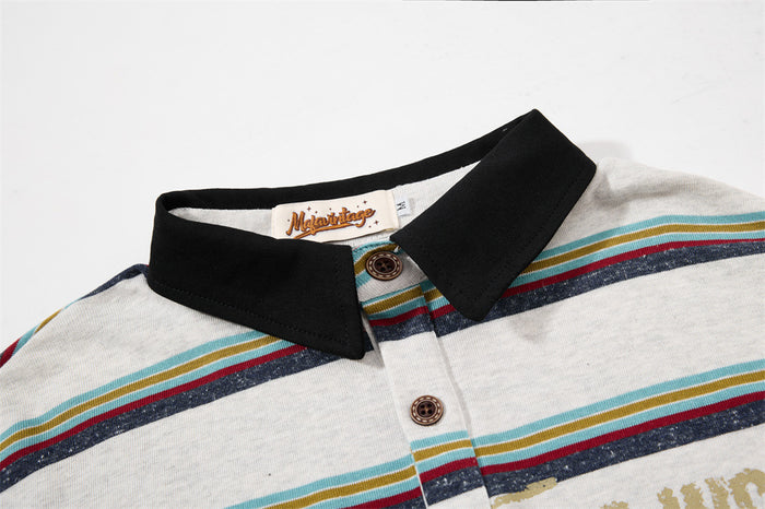 Close-up of black collar, button placket, and striped knit fabric on a layered polo shirt