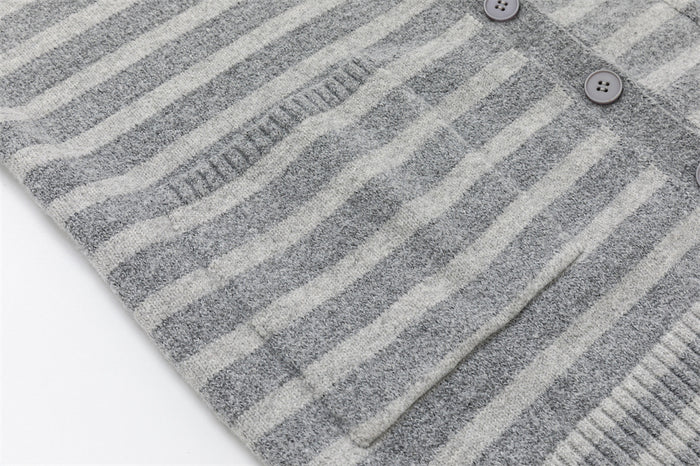 Close-up of the cardigan front pocket and button placket on gray striped knit fabric