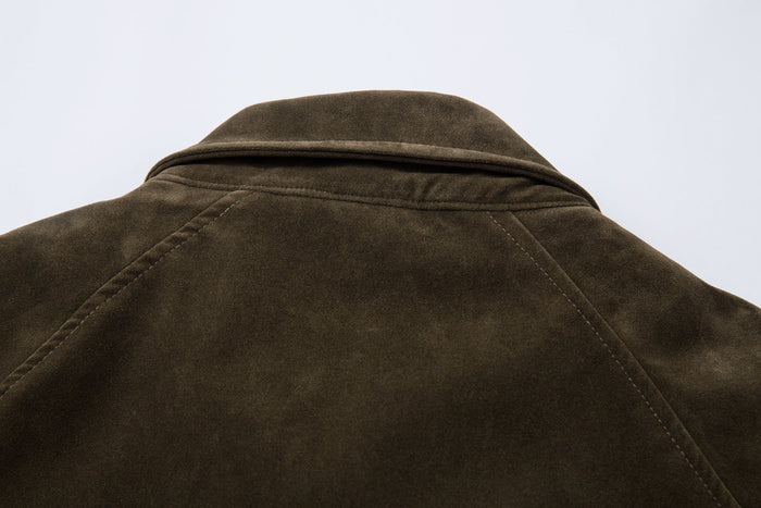 Close-up of the olive jacket collar and shoulder seam in suede texture