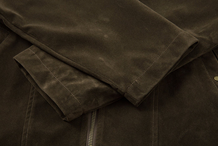 Close-up of the olive jacket sleeve cuff and zip front seam