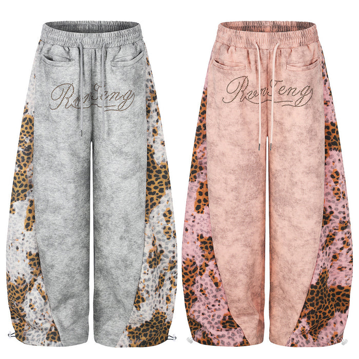 Front view of wide-leg sweatpants in gray and pink with leopard print side panels and rhinestone script