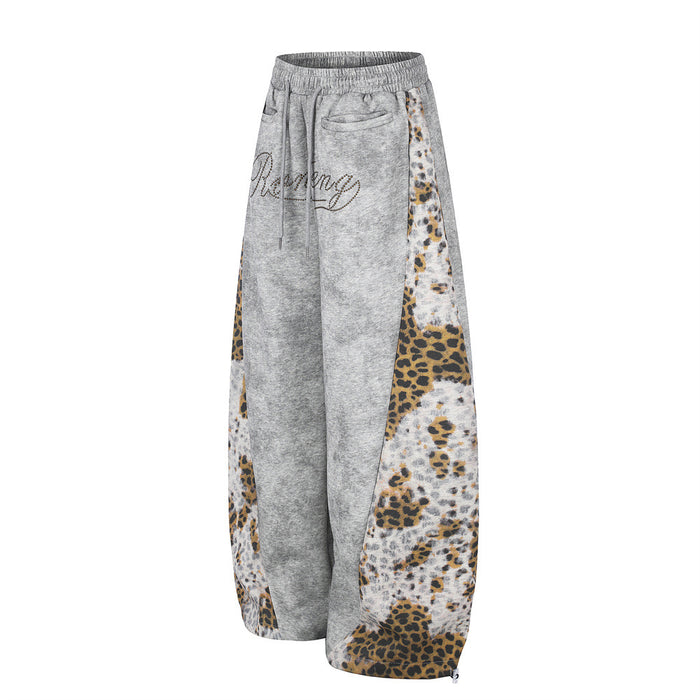 Side view of gray wide-leg sweatpants with patchwork leopard print panels and elastic waist