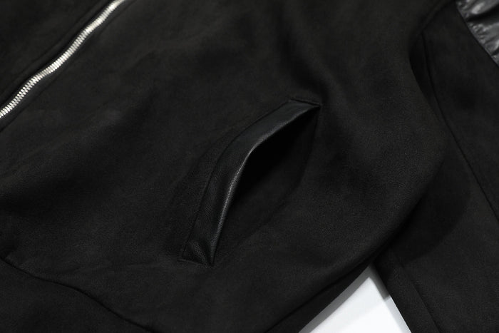 Close-up of black faux leather pocket trim and textured jacket fabric