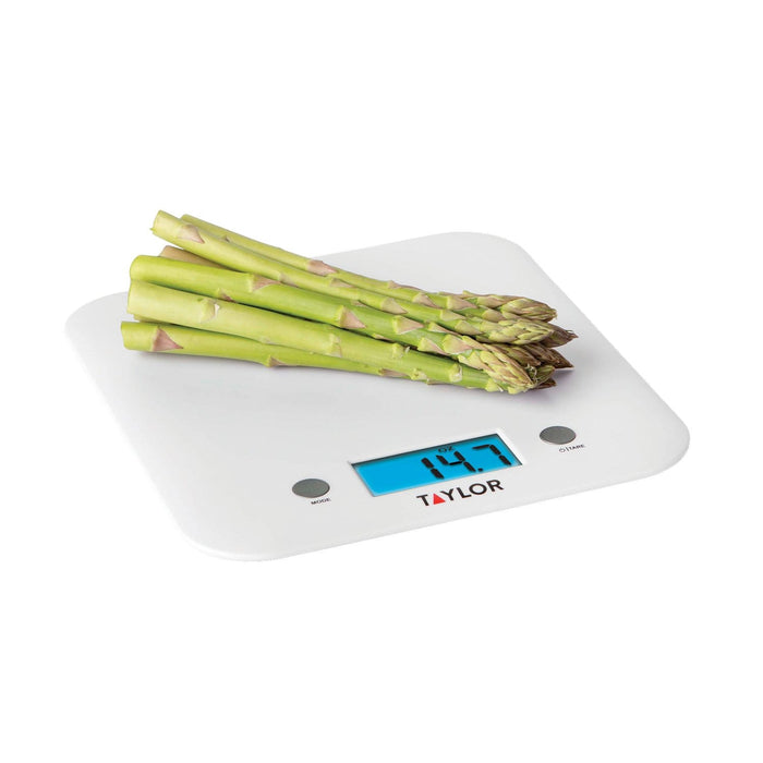White Taylor Ultra Thin Digital Kitchen Scale with asparagus stacked on top and blue backlit display reading 14.7 oz