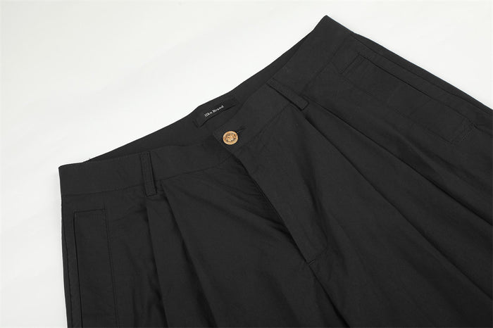 Black pleated waistband and front pocket detail on trousers